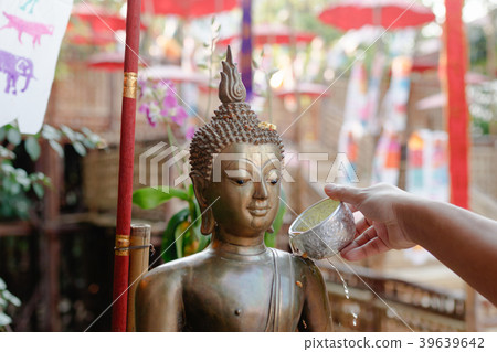 Sprinkle water onto a Buddha image. 39639642