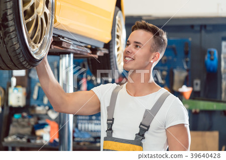 Portrait of a car tuning specialist smiling while Portrait of a car tuning specialist smiling while 39640428