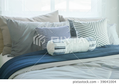White bolster and pillows on bed in modern bedroom 39641004