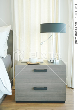 night table with reading lamp,coffee cup and book 39641031