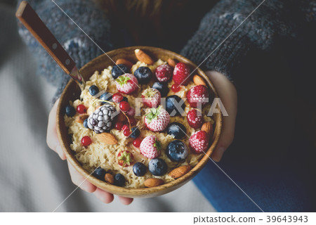 Woman hands holding oatmeal porridge with frozen Woman hands holding oatmeal porridge with frozen 39643943