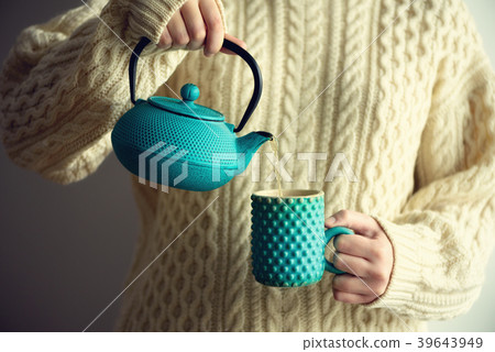 Woman in warm knitted woolen sweater holds Woman in warm knitted woolen sweater holds 39643949