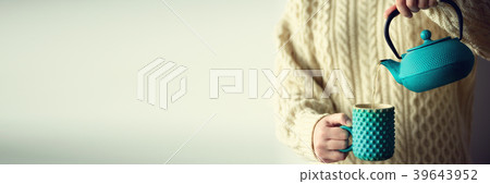 Woman in warm knitted woolen sweater holds Woman in warm knitted woolen sweater holds 39643952