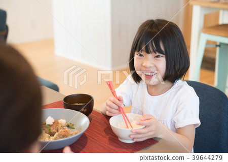 Elementary school girl talking with her mother while eating Elementary school girl talking with her mother while eating 39644279
