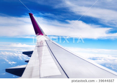 Travel concept. Wing of airplane flying above the 39644887