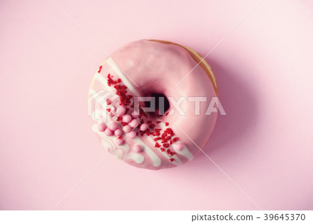 Sweet doughnut with pink icing on pastel 39645370