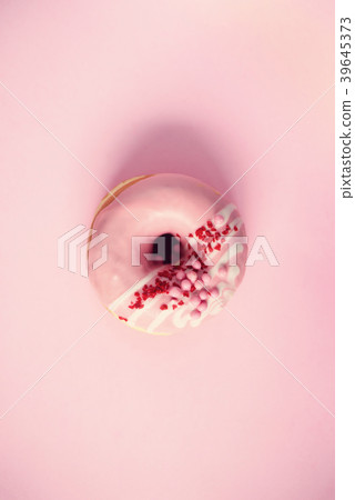 Sweet doughnut with pink icing on pastel Sweet doughnut with pink icing on pastel 39645373