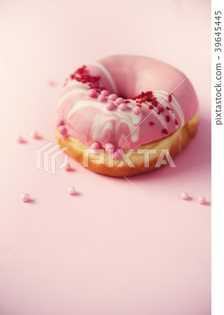 Sweet doughnut with pink icing on pastel Sweet doughnut with pink icing on pastel 39645445