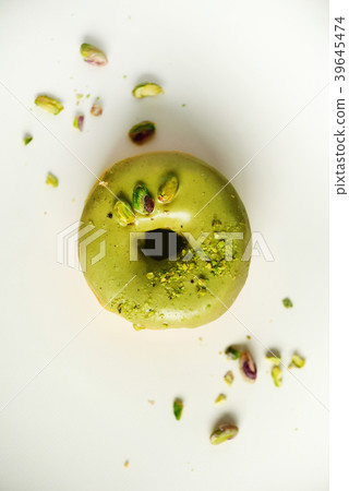 Sweet doughnut with green glaze and pistachio on 39645474