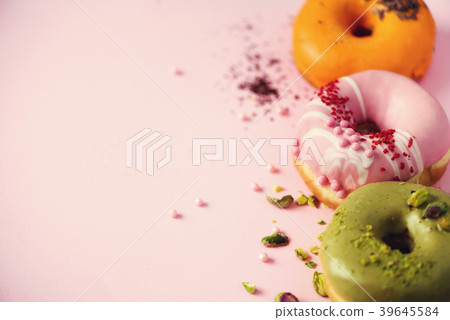 Colorful donuts with icing on pastel pink 39645584