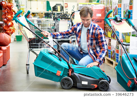 Man chooses lawn mower in store 39646273