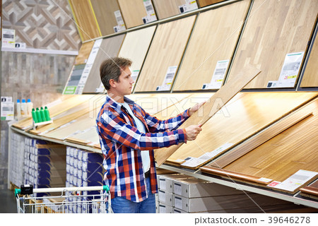 Man chooses floorboard for home renovation 39646278