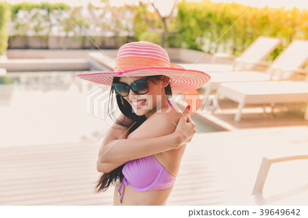 Swimsuit Concept. Beautiful girl in swimsuit is applying sunscre 39649642