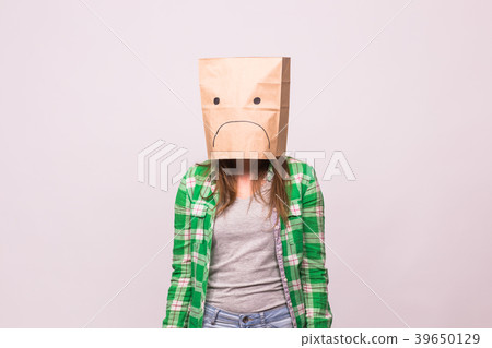 Unhappy girl with sad emoticon on paper bag on her 39650129