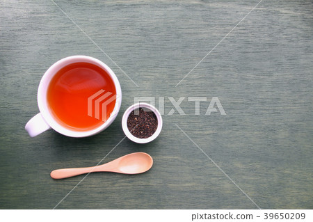 Tea cup with tea, tea leaves and wooden teaspoon 39650209