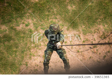 Military man does hanging on climbing equipment. 39651365
