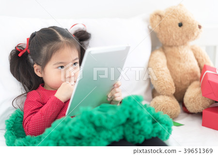 Cute Asian Girl Using Digital Tablet on Bed. Cute Asian Girl Using Digital Tablet on Bed. 39651369