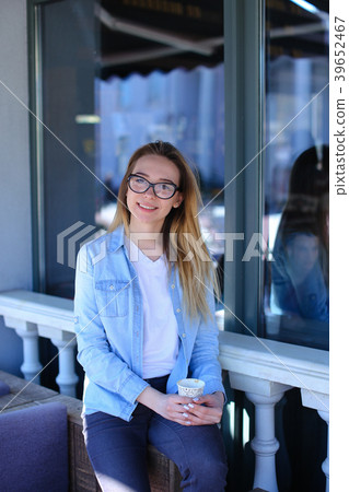 Pretty girl sitting near window and drinking tea Pretty girl sitting near window and drinking tea 39652467