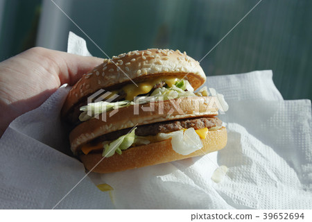 Big juicy burger with cheese in the hand Big juicy burger with cheese in the hand 39652694