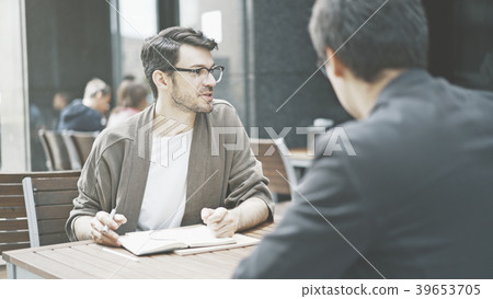 A man in eyeglasses talking listening to his A man in eyeglasses talking listening to his 39653705
