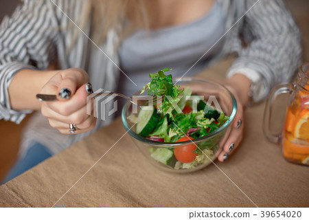 Happy young woman eats healthy vegetable salad 39654020