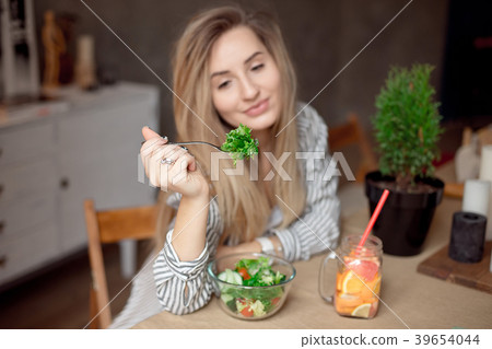 Happy young woman eats healthy vegetable salad 39654044