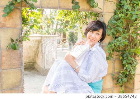 在前法國領事館讀書的女人仍然在一個丘陵公園,可以看到墜毀的港口 在前法國領事館讀書的女人仍然在一個丘陵公園,可以看到墜毀的港口 39654748