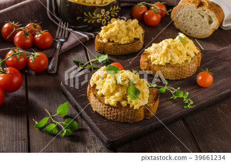 Scrambled eggs with herbs and garlic on toasted bread Scrambled eggs with herbs and garlic on toasted bread 39661234