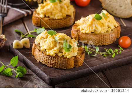 Scrambled eggs with herbs and garlic on toasted bread Scrambled eggs with herbs and garlic on toasted bread 39661244