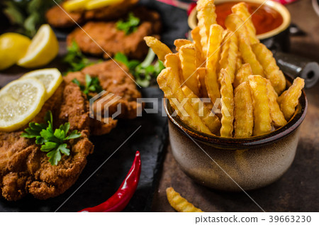 Schnitzel with fries, salad and herbs 39663230