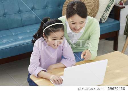 Mother and daughter in living room with laptop 39670458