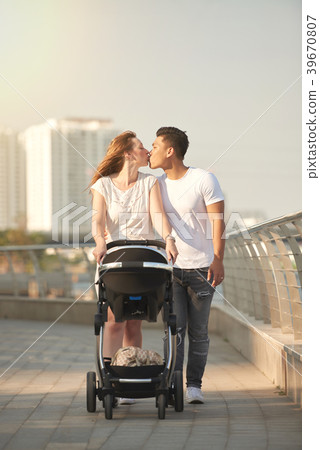 Affectionate Couple Walking with Baby Affectionate Couple Walking with Baby 39670807