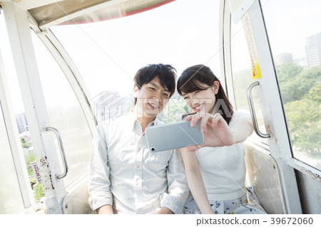 Couple riding a ferris wheel 39672060