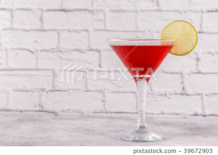 Glass of cosmopolitan cocktail decorated with lime 39672903