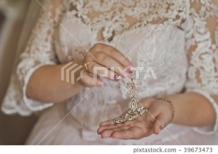 The bride holds in her hands the beautiful jewelry 39673473