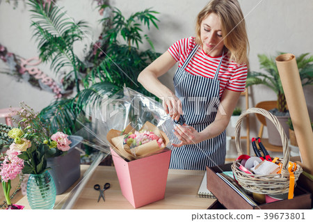 Portrait of female florist with stapler decorating Portrait of female florist with stapler decorating 39673801