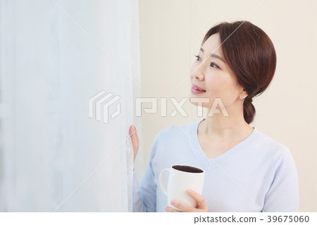 A housewife standing at a window A housewife standing at a window 39675060