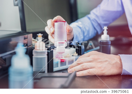 The man completes the ink container in his printer The man completes the ink container in his printer 39675061