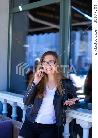 Young woman in glasses speaking by smartphone at 39677204