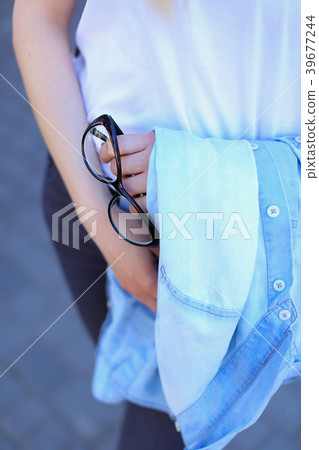 Female person standing with glasses outside. 39677244