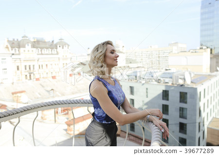 Young female person standing on balcony with Young female person standing on balcony with 39677289