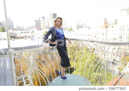 Beautiful businesswoman standing on balcony with Beautiful businesswoman standing on balcony with 39677365