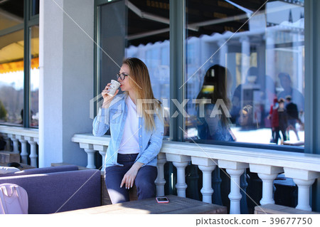 Girl drinking tea at street cafe in morning. Girl drinking tea at street cafe in morning. 39677750