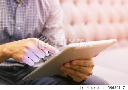 Young businessman sitting sofa using tablet Young businessman sitting sofa using tablet 39680147