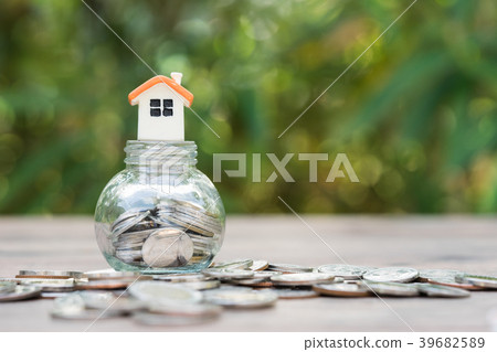 House model on coins stack on jar of coins. 39682589