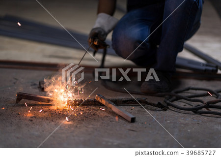 Craftsman in a welding mask and welders leathers. 39685727