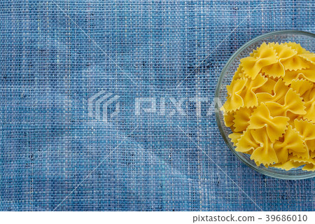 farfalle macaroni Pasta in glass cup on blue farfalle macaroni Pasta in glass cup on blue 39686010