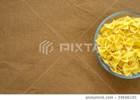 farfalle macaroni Pasta in a glass cup on a brown farfalle macaroni Pasta in a glass cup on a brown 39686105