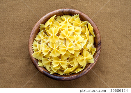 farfalle macaroni pasta in a wooden bowl on a farfalle macaroni pasta in a wooden bowl on a 39686124
