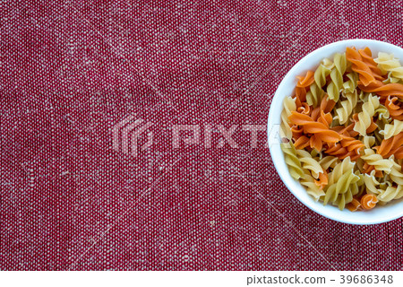 Multicolor spiral macaroni pasta in a white bowl Multicolor spiral macaroni pasta in a white bowl 39686348